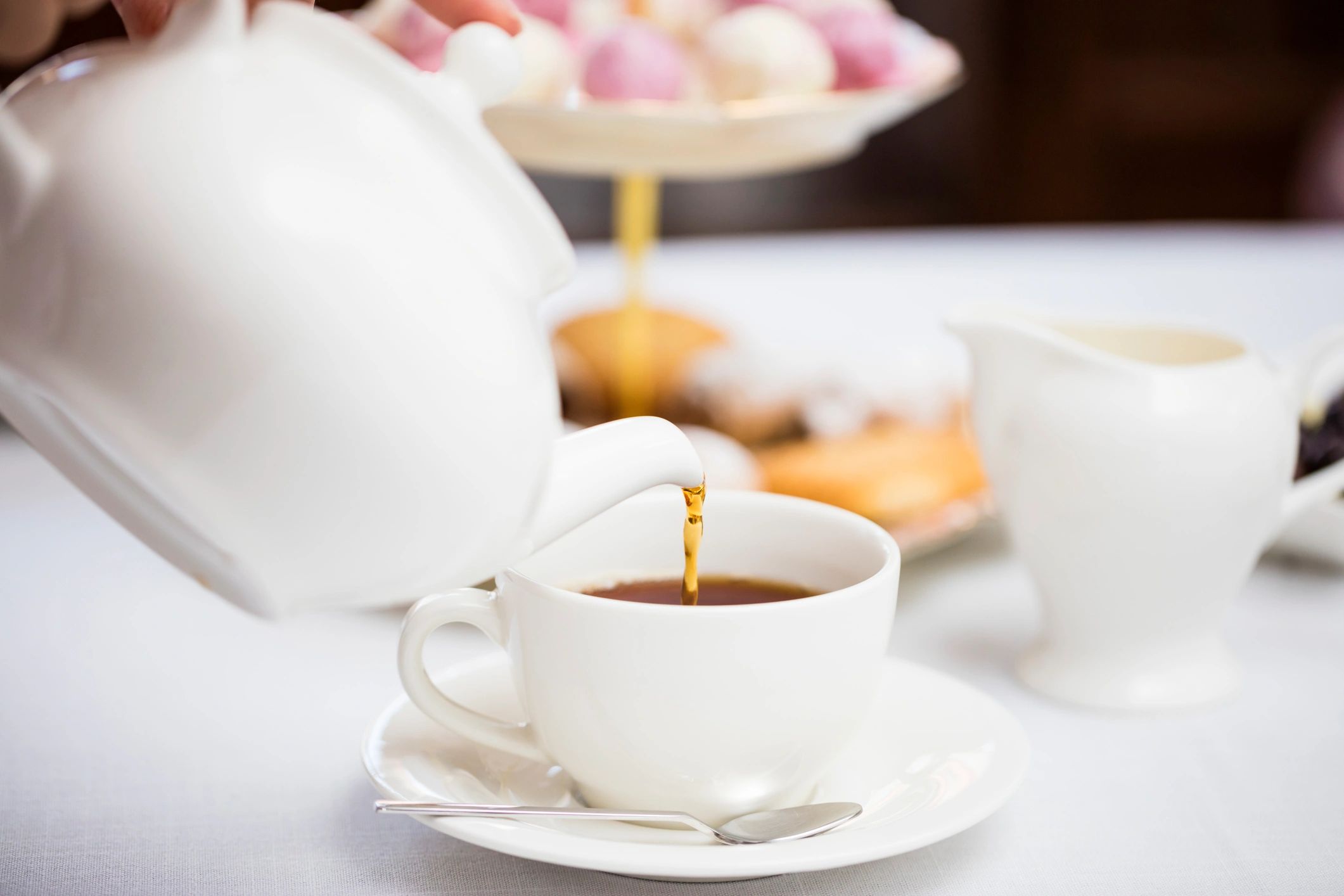 Pouring tea into a ceramic cup during a styled ceremony moment