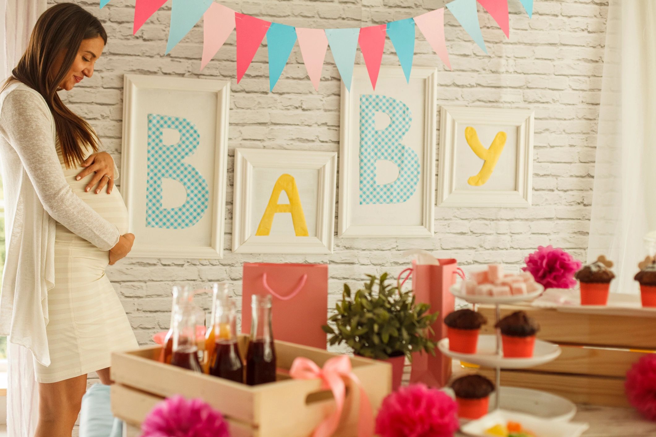 Pregnant woman posing in front of a baby shower set up