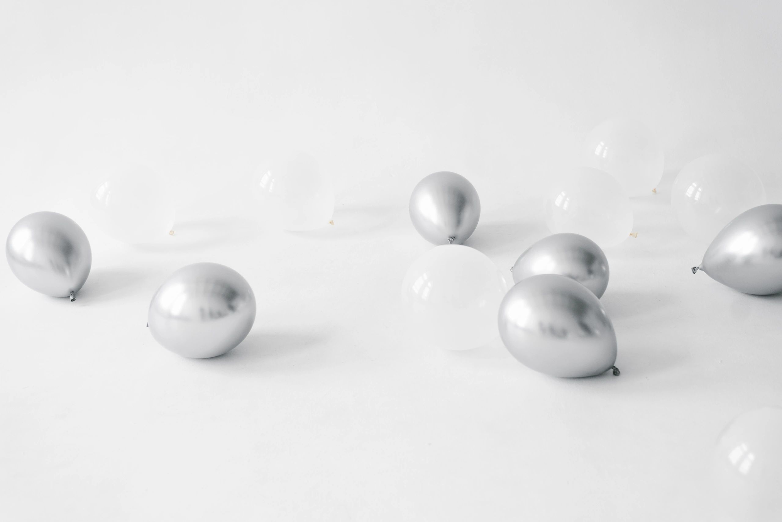 Silver and white balloon backdrop styling for a celebration