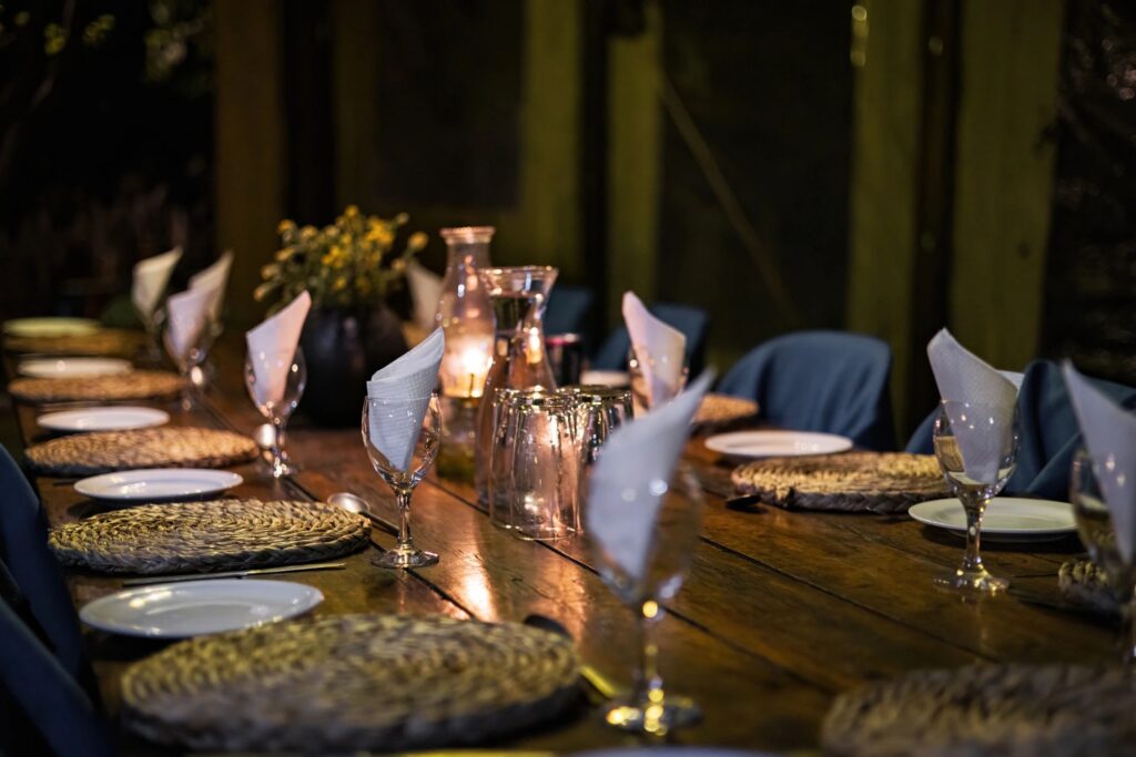 Candlelit Dining Table with Plates and Glasses Set for Guests